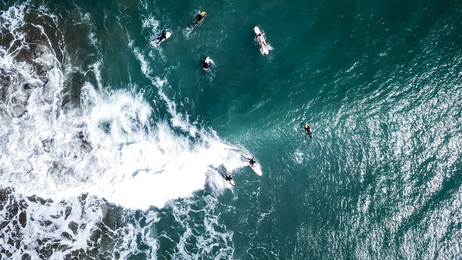 Bild von Surfer:innen auf einer Welle