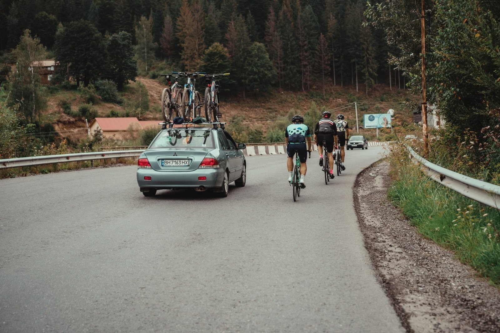 Das Bild zeigt symbolisch für die neuen Regelungen für Autowerbung in Frankreich ein Auto, das von Fahrradfahrern auf einer Landstraße überholt wird.