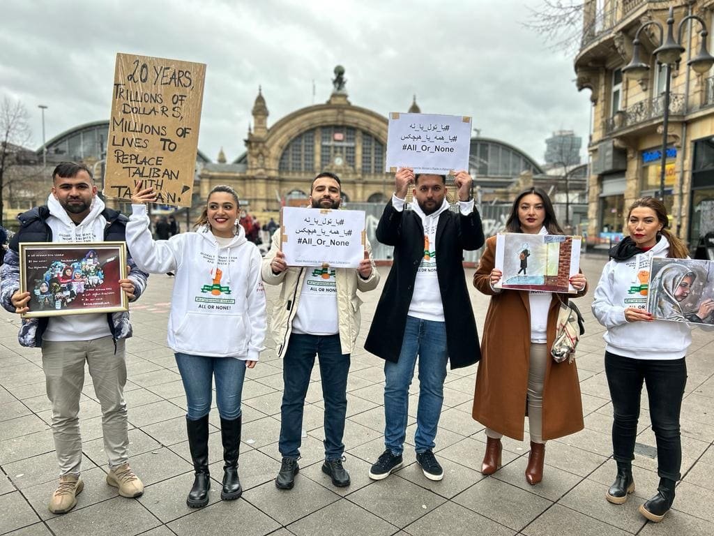 Minna Massoumi zeigt gemeinsam mit anderen Aktivist:innen auf einer Demonstration, wie Aktivismus aussieht