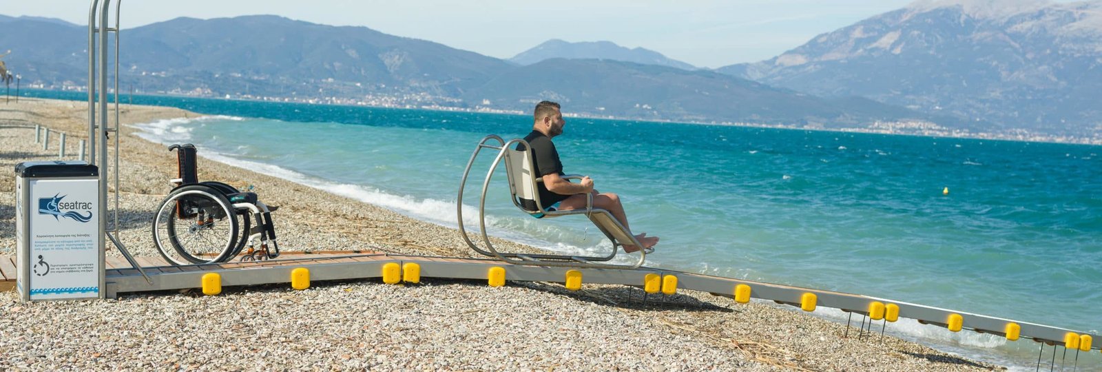 Ein Mann fährt auf dem Seatrac Richtung Meer, barrierefrei