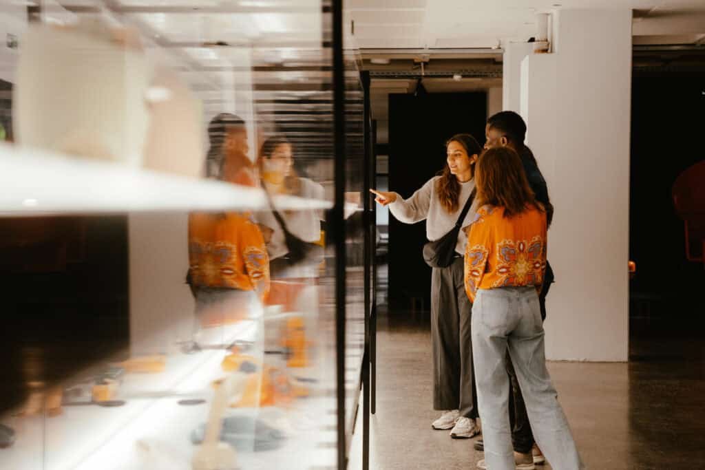 Drei Personen stehen vor einer Vitrine im Museum.