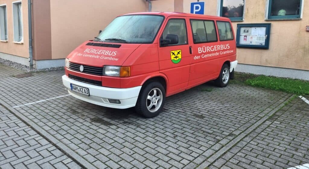 Roter Bus parkt vor einer Hauswand