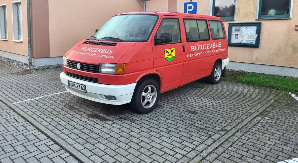 Roter Bus parkt vor einer Hauswand