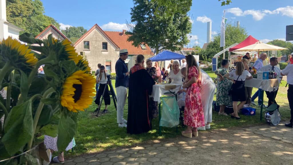 Hochzeitsgesellschaft draussen. Menschen an Stehtischen.