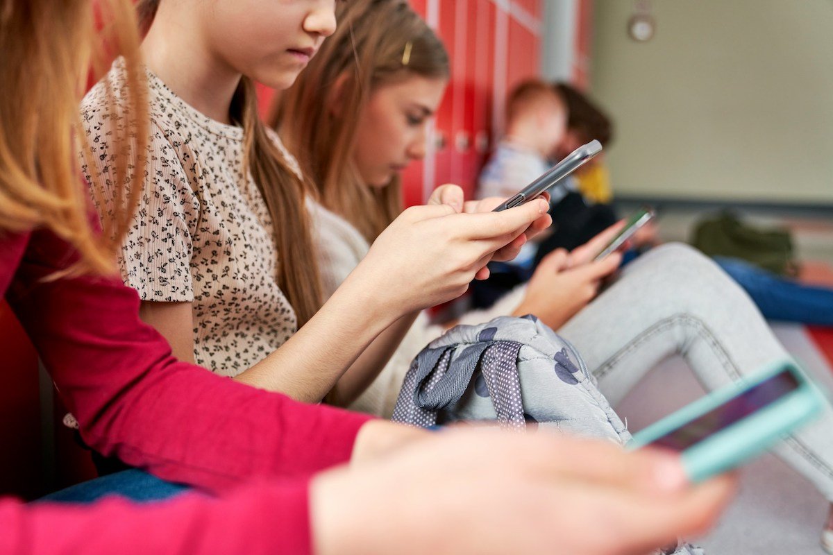 Schülerinnen mit Handys in Schulen