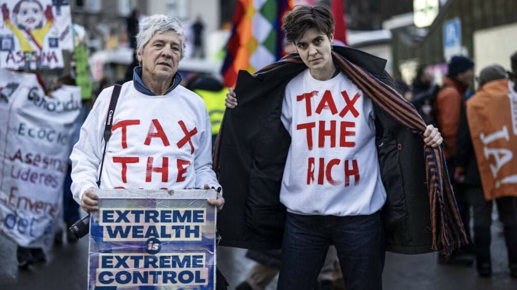Marlene Engelhorn und ein weiterer Mann mit weißen Pullis an, auf denen steht, tax the rich.