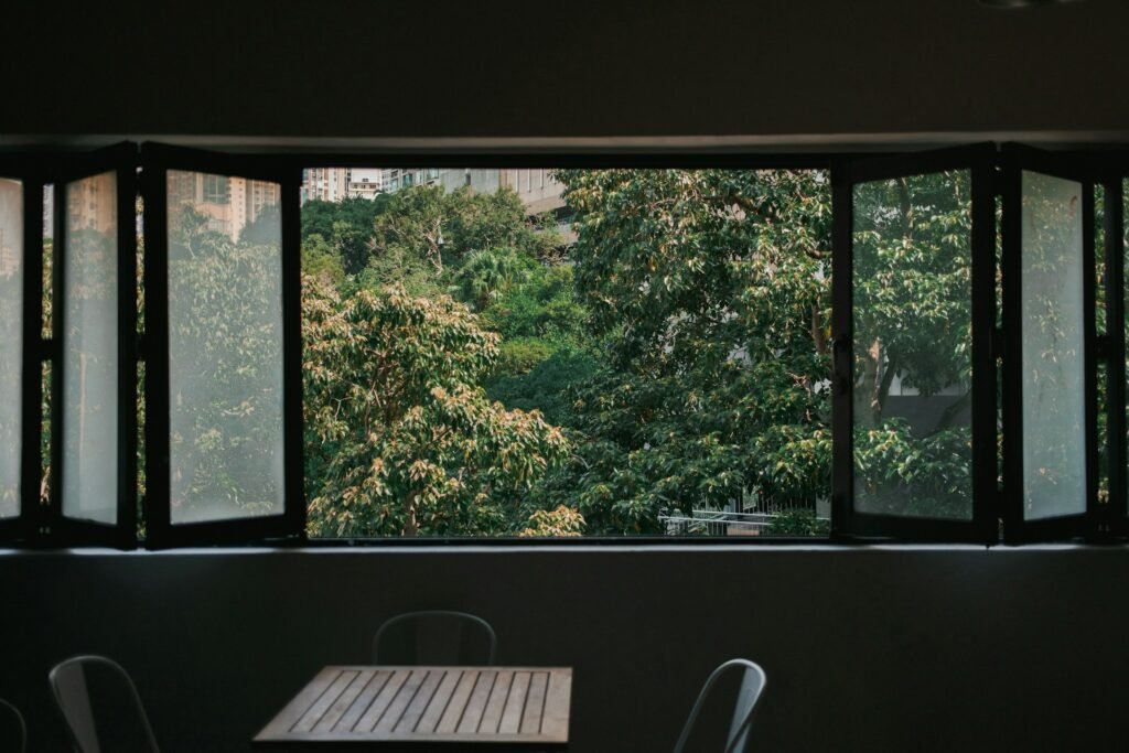 Norwegen ist Vorreiter bei humanen und grünen Gefängnissen. Symbolbild offenes Fenster in Natur. Credits: https://unsplash.com/de/fotos/ein-desktop-computer-der-auf-einem-fenster-sitzt-9sz74-9XW1Q